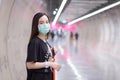 Asian beautiful woman wears black shirt and medical face mask while she walk into Subway tunne. health care,pollution PM2.5 and