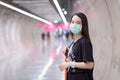 Asian beautiful woman wears black shirt and medical face mask while she walk into Subway tunne. health care,pollution PM2.5 and