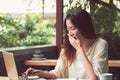 Asian woman is yawning while working