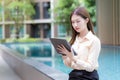 Asian beautiful working woman uses tablet or Ipad to search data in working from anywhere concept