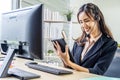 Asian beautiful young girl call center operator in headset answering calls and using tablet at call center Royalty Free Stock Photo