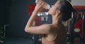 Woman drinking water from the bottle in gym after training exercise workout Royalty Free Stock Photo