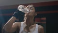 Woman drinking water from the bottle in gym after training exercise workout Royalty Free Stock Photo