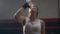 Woman drinking water from the bottle in gym after training exercise workout Royalty Free Stock Photo