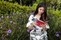 Asian beautiful young woman reading a book in outdoor garden Royalty Free Stock Photo