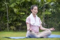 Asian Beauty and healthy woman exercise and doing meditation of yoga on exercise mat in the outdoor park -  fitness, sport , yoka Royalty Free Stock Photo