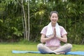 Asian Beauty healthy woman exercise and doing meditation of yoga on exercise mat in the outdoor park -  fitness, sport, yoka Royalty Free Stock Photo