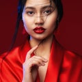 Asian Beauty Woman with Red Lips Make up. Chinese Beautiful Model Face Portrait over Red Background. Fashion Japanese Girl Kimono