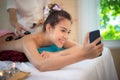 Asian beauty woman lying down on massage bed with traditional hot stones along the spine at Thai spa and wellness center. She tak Royalty Free Stock Photo