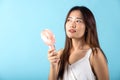 Asian beauty young woman holding pink portable electric mini fan near her face Royalty Free Stock Photo