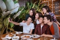 Asian bestfriend group take selfie with smartphone while having garden party