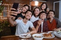 Asian bestfriend group take selfie with smartphone while having garden party