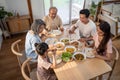 Asian Big happy family spend time have lunch on dinner table together. Little kid daughter enjoy eating foods with father, mother Royalty Free Stock Photo