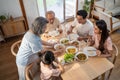 Asian Big happy family spend time have lunch on dinner table together. Little kid daughter enjoy eating foods with father, mother Royalty Free Stock Photo