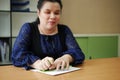 Asian blind person woman hands writing braille by using slate and stylus tools making embossed printing for Braille character
