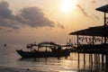 Asian boat and house silhouette on orange sky. Sunset sea landscape photo. Sunrise on Koh Rong island. Royalty Free Stock Photo