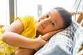 Asian Boy with arms behind his head resting on a pillow Royalty Free Stock Photo