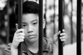 Asian boy behind iron bars