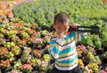 Asian boy carrying tripods standing in flower garden