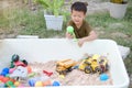 Asian boy child playing with sand in the garden at home backyard, Little Kid playing with sand toys Royalty Free Stock Photo