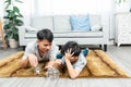 Asian boy in clothes sitting on the floor, in front of him is a table with a piggy bank. boy took Royalty Free Stock Photo