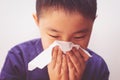 Asian boy cold flu illness tissue blowing runny nose Royalty Free Stock Photo