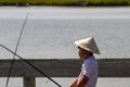 An asian boy with conical hat  fising on a bridge Royalty Free Stock Photo