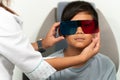 Asian boy in a duochrome test review with red and green 3D glasses