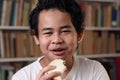 Asian boy eating bread with chocolate cream, student enjoys breakfast or snacks of toast with jam Royalty Free Stock Photo