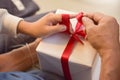 Asian boy and elderly man holding on red ribbon of white gift bo Royalty Free Stock Photo