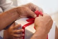 Asian boy and elderly man holding on red ribbon of white gift bo Royalty Free Stock Photo