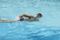 Asian boy front crawl swims in swimming pool Royalty Free Stock Photo