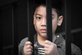 Asian boy Hand in jail looking out the window