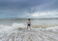 An Asian boy has felt happy and fun on the beach with a cloudy sky