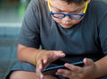 Asian boy have a serious face while playing game on smartphone Royalty Free Stock Photo