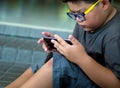 Asian boy have a serious face while playing game on smartphone Royalty Free Stock Photo