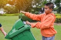 Asian boy holding empty bottle into the trash