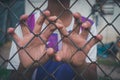 Asian boy holding metal fence by alone. Royalty Free Stock Photo