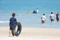 Asian Boy holds black rubber ring On the beach Background sea at Suan Son Pradipat Beach , Prachuap Khiri Khan , Thailand.