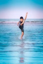Asian boy kicking splashing water on a Beach for Children Summer Vacation happiness concept Royalty Free Stock Photo