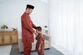 Asian boy kissing his father`s hand when celebrating Happy Eid Ul- Royalty Free Stock Photo