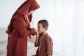 Asian boy kissing his mother`s hand when celebrating Happy Eid Ul- Royalty Free Stock Photo