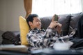 Asian boy laying down on furniture and use mobile phone Royalty Free Stock Photo