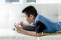 Asian boy laying on sofa and play game Royalty Free Stock Photo