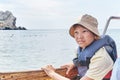 An Asian boy in life jacket on pleasure boat on sea. Royalty Free Stock Photo