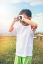 Asian boy looking through a telescope. Child relaxing holiday. V Royalty Free Stock Photo