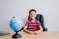 Asian boy looking at world map Royalty Free Stock Photo