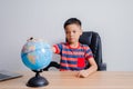Asian boy looking at world map Royalty Free Stock Photo