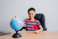 Asian boy looking at world map Royalty Free Stock Photo