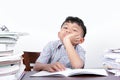 Asian boy looks bored studying on a desk and white background